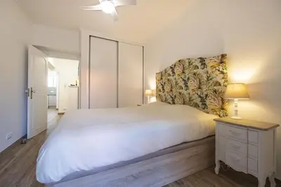 a bedroom with a large white bed and a nightstand at Apartment - The Historical Center of Funchal in Alojamento Local in Funchal