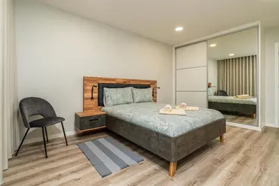 a bedroom with a bed and a chair and a mirror at Casa Barros Serra in Calheta