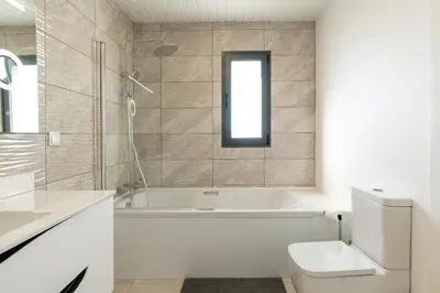 a bathroom with a tub and a toilet and a window at Casa Barros Serra in Calheta