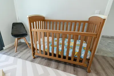 a crib and a chair in a room at Casa Barros Serra in Calheta