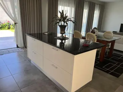 a kitchen with a island with a black counter top at Moradia com piscina no Caniço in Caniço