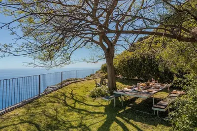 a picnic table under a tree next to a fence at Botanica Living Magnolia Apt in Quinta Grande