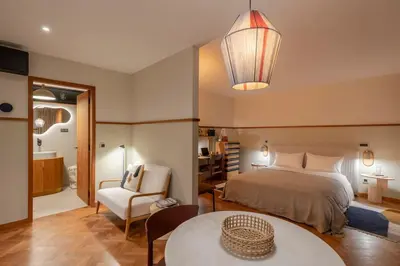 a bedroom with a bed and a table and a chair at Botanica Living Magnolia Apt in Quinta Grande