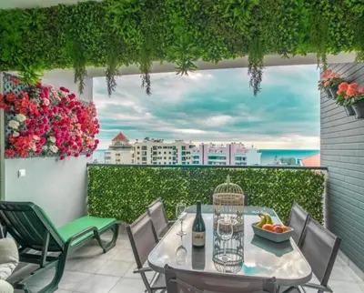 a table and chairs on a balcony with a view at Jardins da Ajuda Apartment in Funchal