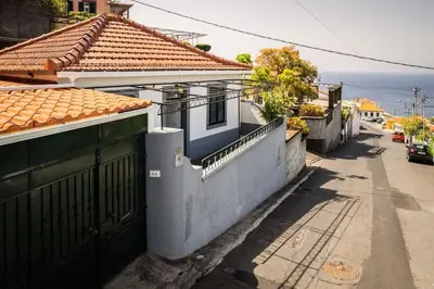 an empty street with houses and a fence at Villa bela vista 20th century house in Funchal