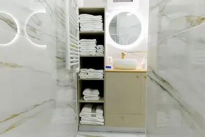 a bathroom with a sink and a shelf with towels at Casa do Sol in Funchal