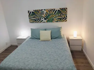 a bedroom with a bed with two night stands and a painting at Casa do Sol in Funchal