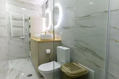 a white bathroom with a toilet and a sink at Casa do Sol in Funchal