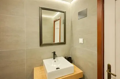 a bathroom with a white sink and a mirror at Casas Maravilha - Casa Grande by Homie in Calheta