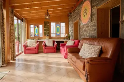 a living room with a couch and red chairs at Casas Maravilha - Casa Grande by Homie in Calheta