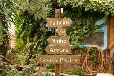 a wooden sign with many signs in a garden at Casas Maravilha - Casa Grande by Homie in Calheta