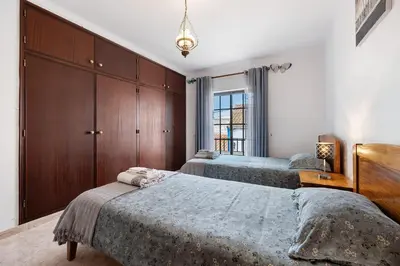 a bedroom with two beds and a large window at Casa Brita in Raposeira