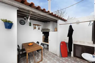a patio with a table and chairs and an oven at Casa Brita in Raposeira
