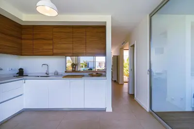a kitchen with white cabinets and a sink at Villa Blue Sagres D in Sagres