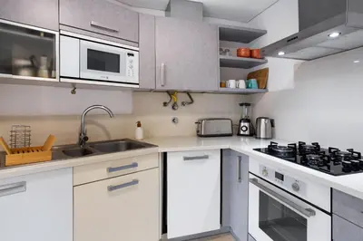 a kitchen with white cabinets and a sink at Forum T0 Plus in Funchal