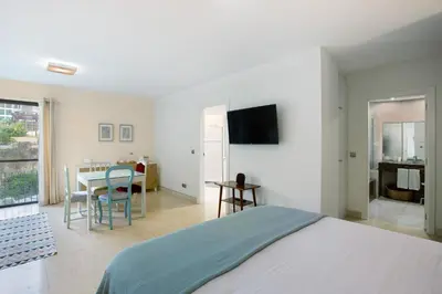 a bedroom with a bed and a table and a television at Forum T0 Plus in Funchal