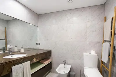 a bathroom with a sink and a toilet and a mirror at Forum T0 Plus in Funchal