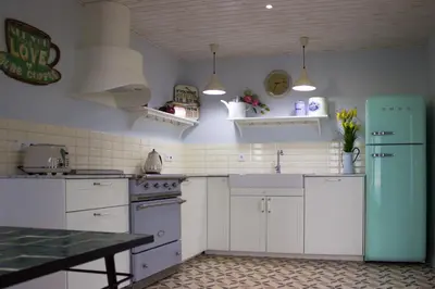 a kitchen with white cabinets and a green refrigerator at Villa Pargo in Fajã da Ovelha