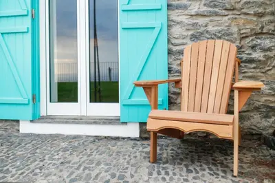 a wooden chair sitting in front of a door at Villa Pargo in Fajã da Ovelha