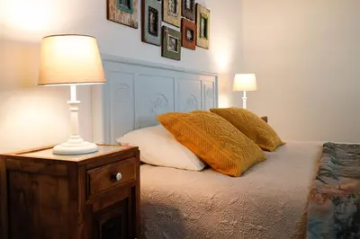 a bed with two pillows and a lamp on a night stand at Villa Pargo in Fajã da Ovelha