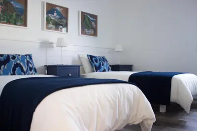 two beds with blue and white sheets in a room at Villa Pargo in Fajã da Ovelha