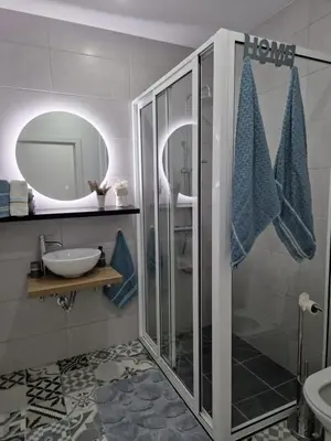 a bathroom with a shower and a sink and a mirror at B - BEAUTIFUL 2 Bedroom Modern Townhouse with Private Parking in Machico