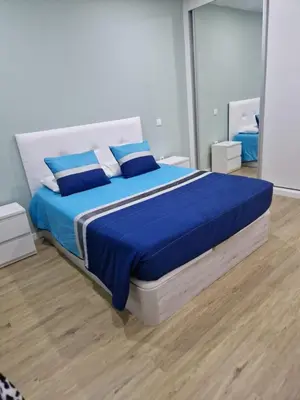 a bedroom with a large bed with blue sheets at B - BEAUTIFUL 2 Bedroom Modern Townhouse with Private Parking in Machico