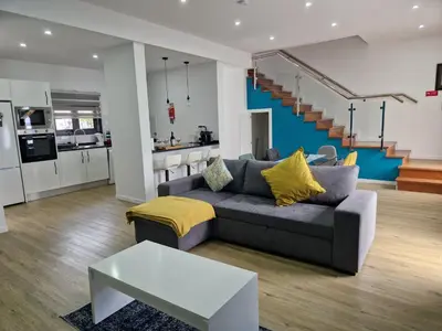 a living room with a grey couch and a kitchen at B - BEAUTIFUL 2 Bedroom Modern Townhouse with Private Parking in Machico