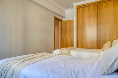 a bedroom with two beds and a wooden wall at Funchal Atrium, a Home in Madeira in Funchal