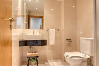 a bathroom with a toilet and a sink at Funchal Atrium, a Home in Madeira in Funchal