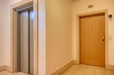 a hallway with a wooden door and a tile floor at Funchal Atrium, a Home in Madeira in Funchal