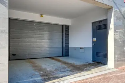 a garage with a blue door in a building at Funchal Atrium, a Home in Madeira in Funchal
