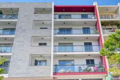 an apartment building with balconies and trees at Funchal Atrium, a Home in Madeira in Funchal