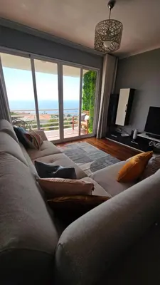 a living room with a couch with a view of the ocean at Seaview Relax Apartment in Caniço