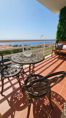 a table and chairs on a balcony with the ocean at Seaview Relax Apartment in Caniço