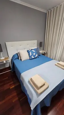 a bedroom with a blue bed with blue sheets and pillows at Seaview Relax Apartment in Caniço