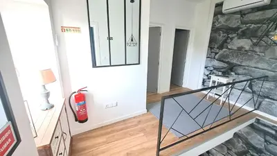 a staircase with a fire extinguisher in a room with a stone wall at Espirito do Mar - Premium Villa with Jacuzzi in Estreito da Calheta