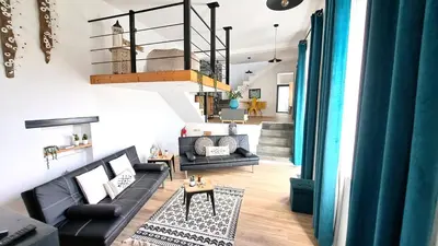 a living room with black furniture and a staircase at Espirito do Mar - Premium Villa with Jacuzzi in Estreito da Calheta