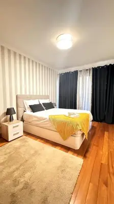 a bedroom with a white bed and a rug at By the Sea IV - Cosy flat in Funchal