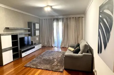 a living room with a couch and a television at By the Sea IV - Cosy flat in Funchal