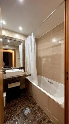 a bathroom with a tub and a sink and a bath tub at By the Sea IV - Cosy flat in Funchal