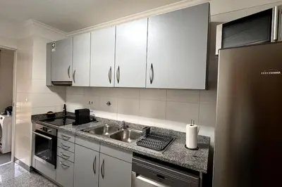 a kitchen with white cabinets and a sink at By the Sea IV - Cosy flat in Funchal