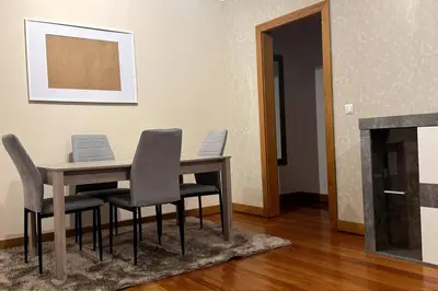 a dining room table with chairs and a fireplace at By the Sea IV - Cosy flat in Funchal