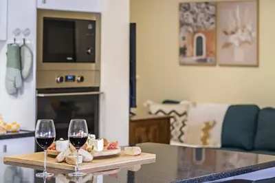 two glasses of wine on a table in a living room at Quinta dos Landeiros - Prosa Verde by Homie in Machico
