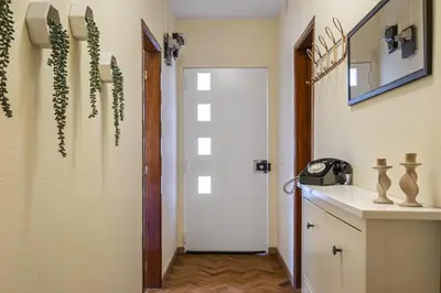 a hallway with a white door and some plants at Quinta dos Landeiros - Prosa Verde by Homie in Machico