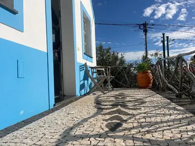 a cobblestone walkway outside of a house with a window at Lucky Lemons Boutique Houses Madeira 1 in Calheta