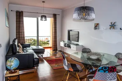 a living room with a glass table and chairs at Apartamento Bartolomeu By Horizon View Madeira in Caniço