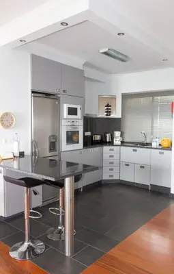 a kitchen with stainless steel appliances and a black counter top at Apartamento Bartolomeu By Horizon View Madeira in Caniço