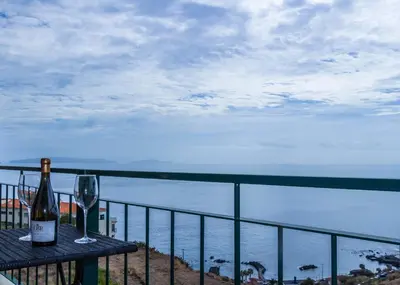 a bottle of wine sitting on a table with a glass at Apartamento Bartolomeu By Horizon View Madeira in Caniço