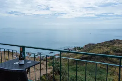 a bottle of wine sitting on a table on a balcony at Apartamento Bartolomeu By Horizon View Madeira in Caniço